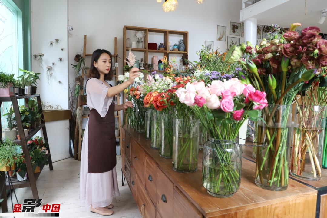 王黎媛是一名河南姑娘，在昆明念完大學(xué)后，就再也舍不下春城的藍(lán)天陽(yáng)光、青山碧水，更舍不下這里的四時(shí)繁花，于是就干脆留了下來(lái)，成了一名媒體人。2017年的時(shí)候又毅然辭去工作，創(chuàng)業(yè)開(kāi)起了花店，成了都市里的一名“花房姑娘”。圖為王黎媛在自己的花店中整理鮮花。新華網(wǎng) 周亞平/攝 念新洪/文
